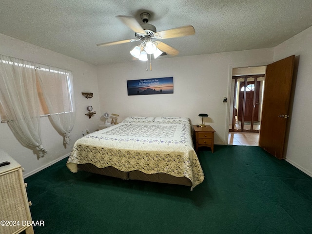 carpeted bedroom with ceiling fan and a textured ceiling