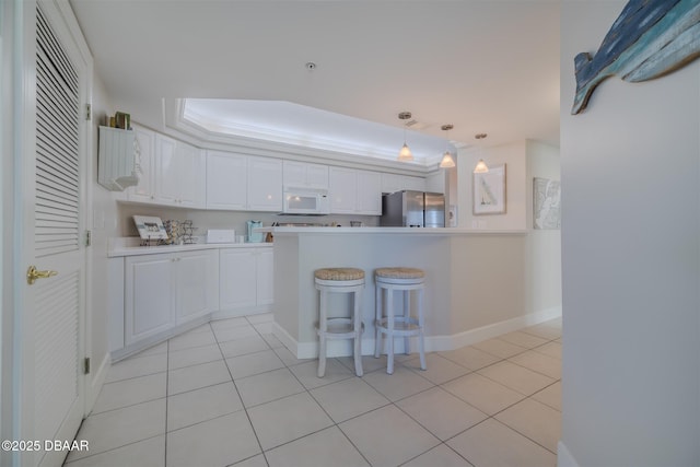 kitchen featuring a kitchen bar, stainless steel fridge with ice dispenser, light tile patterned floors, pendant lighting, and white cabinets