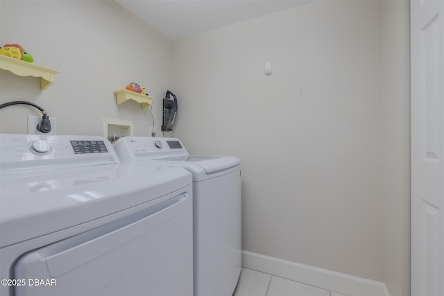 laundry room with washer and dryer and light tile patterned floors