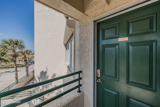 view of exterior entry featuring a balcony