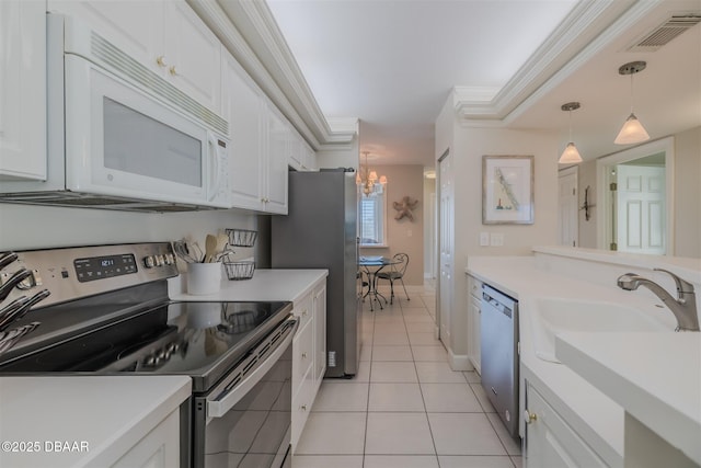 kitchen with light tile patterned flooring, white cabinetry, ornamental molding, pendant lighting, and stainless steel appliances