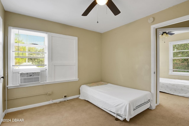 bedroom featuring ceiling fan, cooling unit, and light carpet