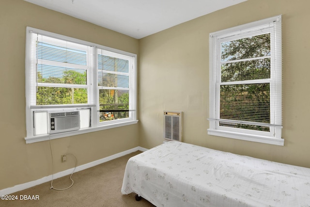 carpeted bedroom featuring multiple windows and heating unit