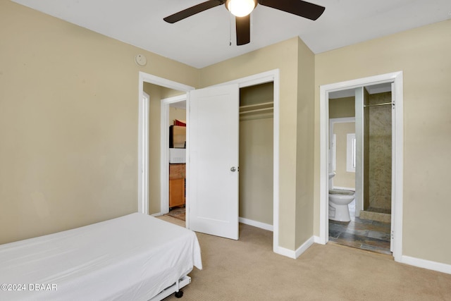 carpeted bedroom with ceiling fan, a closet, and ensuite bath