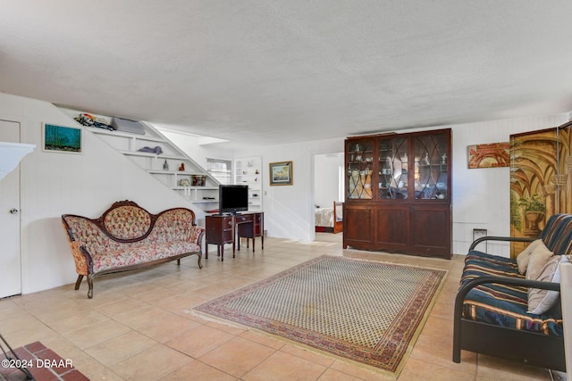 tiled living room featuring a textured ceiling