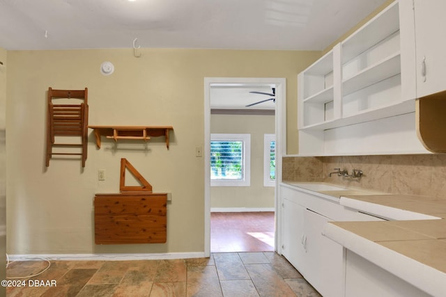 kitchen with white cabinetry, ceiling fan, crown molding, and sink