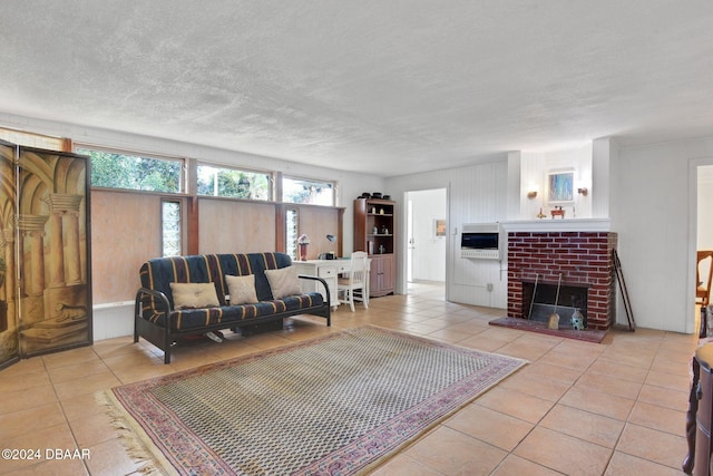 tiled living room featuring a textured ceiling and a brick fireplace