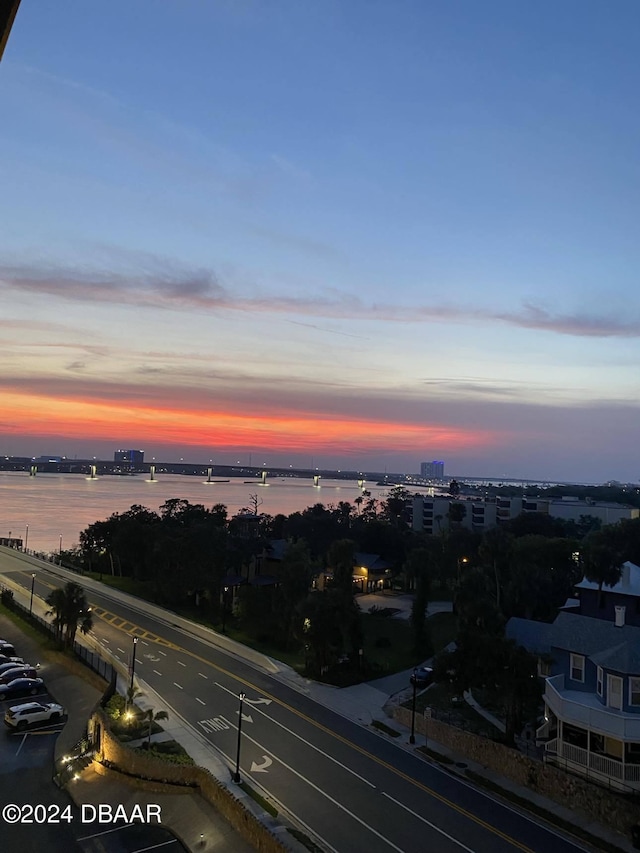 aerial view at dusk featuring a water view