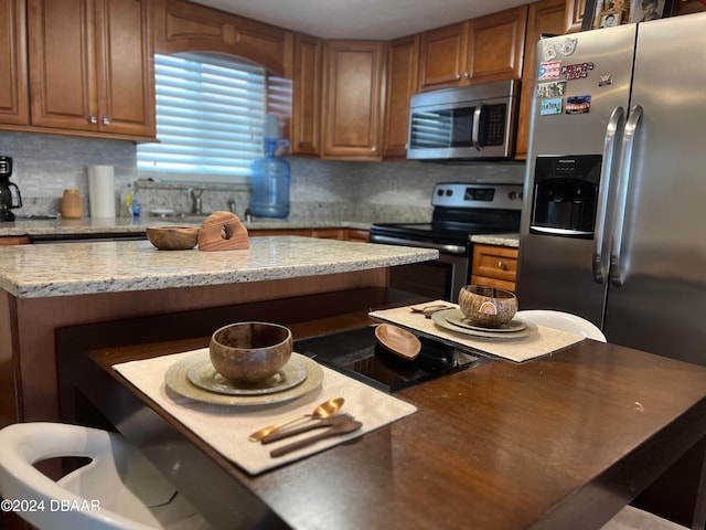 kitchen featuring tasteful backsplash, appliances with stainless steel finishes, sink, and light stone counters