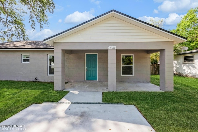 495 6th St, Holly Hill, FL 32117 - view of front of home with a front lawn, concrete block siding, and a patio area