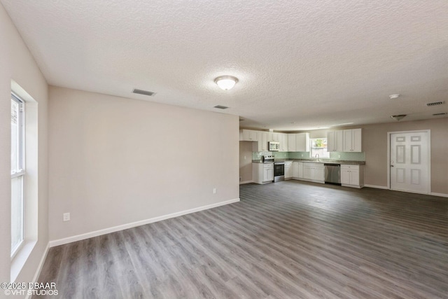 495 6th St, Holly Hill, FL 32117 - unfurnished living room featuring a textured ceiling and dark wood-style floors