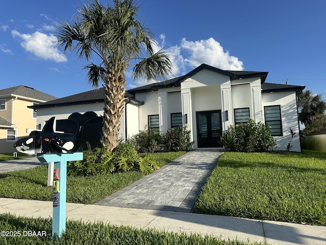 142 Sandpiper Ridge Dr, Ormond Beach, FL 32176 - view of front of home featuring french doors, an attached garage, stucco siding, and a front yard