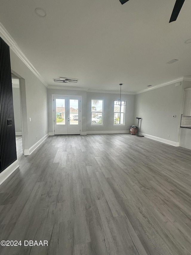 142 Sandpiper Ridge Dr, Ormond Beach, FL 32176 - unfurnished living room with ornamental molding, baseboards, healthy amount of natural light, wood finished floors, and french doors