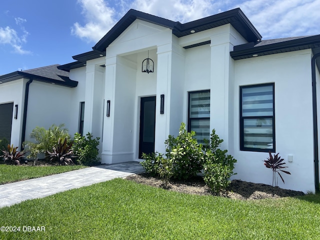142 Sandpiper Ridge Dr, Ormond Beach, FL 32176 - view of front facade featuring stucco siding, roof with shingles, and a front yard