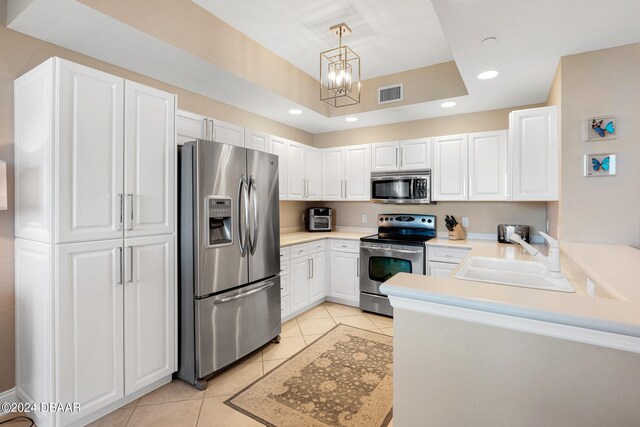 kitchen featuring stainless steel appliances, white cabinetry, sink, light tile patterned floors, and pendant lighting