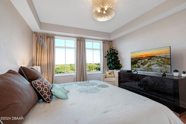 bedroom featuring hardwood / wood-style flooring and a tray ceiling