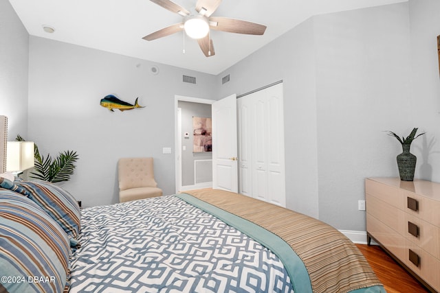 bedroom with ceiling fan, dark hardwood / wood-style floors, and a closet