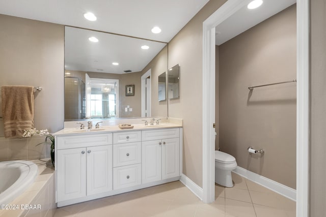 bathroom featuring toilet, vanity, tile patterned floors, and tiled tub