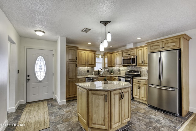 kitchen with decorative backsplash, visible vents, baseboards, stainless steel appliances, and stone tile floors