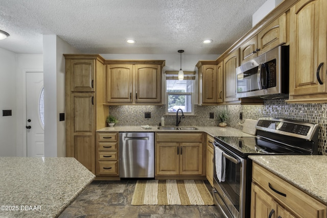 kitchen featuring backsplash, a textured ceiling, appliances with stainless steel finishes, and a sink