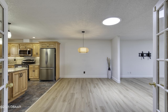 kitchen featuring hanging light fixtures, appliances with stainless steel finishes, a textured ceiling, decorative backsplash, and dark wood-type flooring