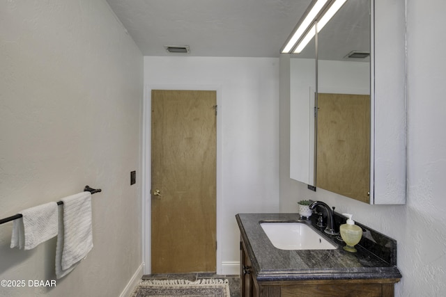 bathroom with vanity, baseboards, and visible vents