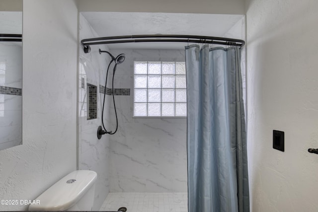 bathroom featuring a textured wall and a shower stall