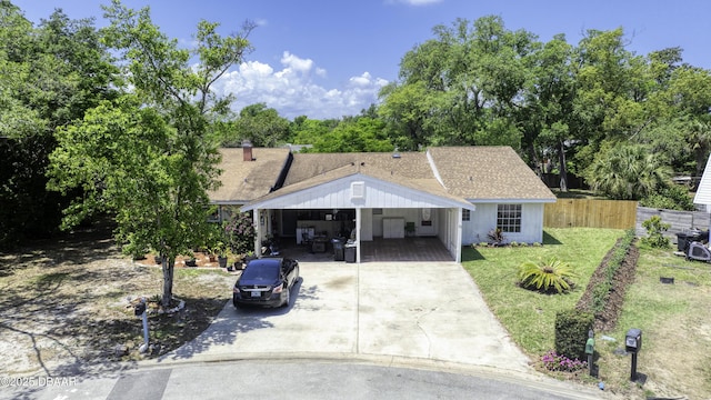 single story home with fence, an attached carport, concrete driveway, and a front lawn