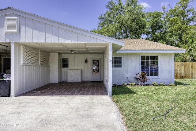 single story home with roof with shingles, fence, a front lawn, an attached carport, and driveway