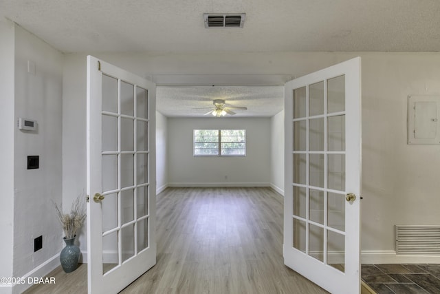 spare room featuring french doors, a textured ceiling, and visible vents