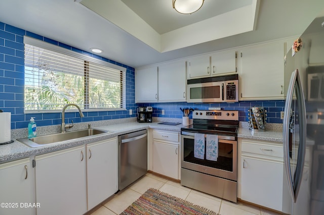 4405 Sea Mist Dr Unit 218, New Smyrna Beach, FL 32169 - kitchen featuring stainless steel appliances, a tray ceiling, decorative backsplash, and light countertops