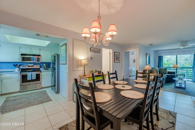 4405 Sea Mist Dr Unit 218, New Smyrna Beach, FL 32169 - dining room with light tile patterned floors, a chandelier, and a ceiling fan