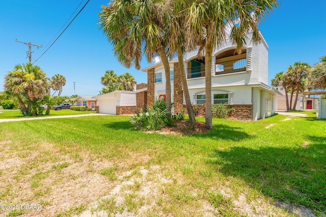 46 Oceanview Ave, Ponce Inlet, FL 32127 - view of front of property with stucco siding, a front lawn, a balcony, and driveway