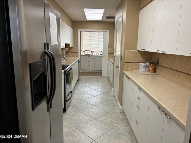 kitchen featuring white cabinets, light tile patterned floors, and stainless steel appliances