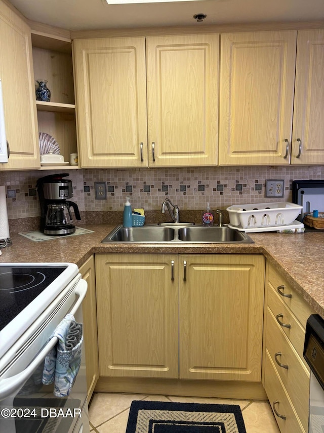 kitchen featuring backsplash, electric stove, sink, and light tile patterned floors