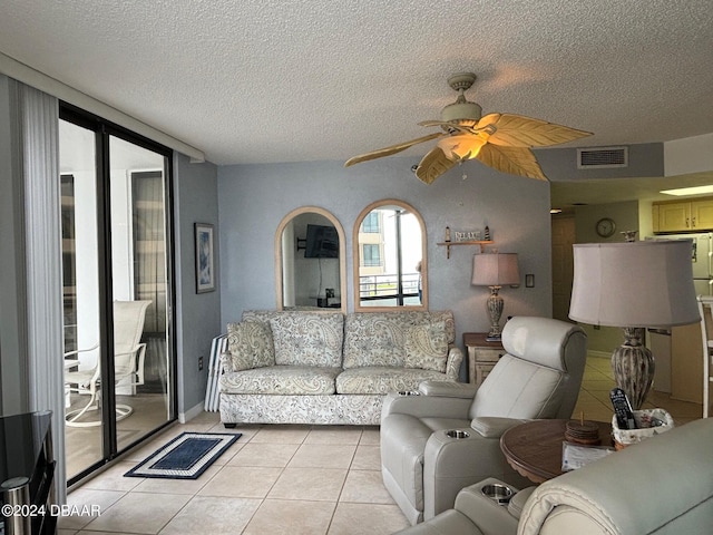 living room with ceiling fan, a textured ceiling, and light tile patterned floors