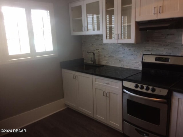 kitchen with dark hardwood / wood-style flooring, sink, tasteful backsplash, stainless steel range with electric cooktop, and white cabinetry