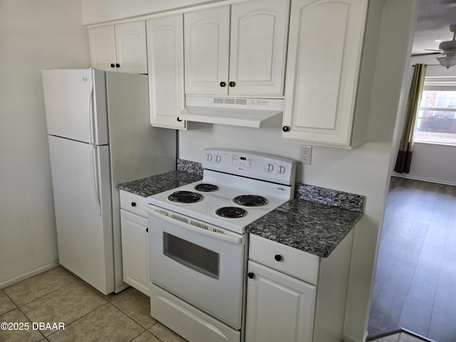 kitchen featuring white appliances, ceiling fan, dark stone countertops, white cabinets, and light tile patterned flooring