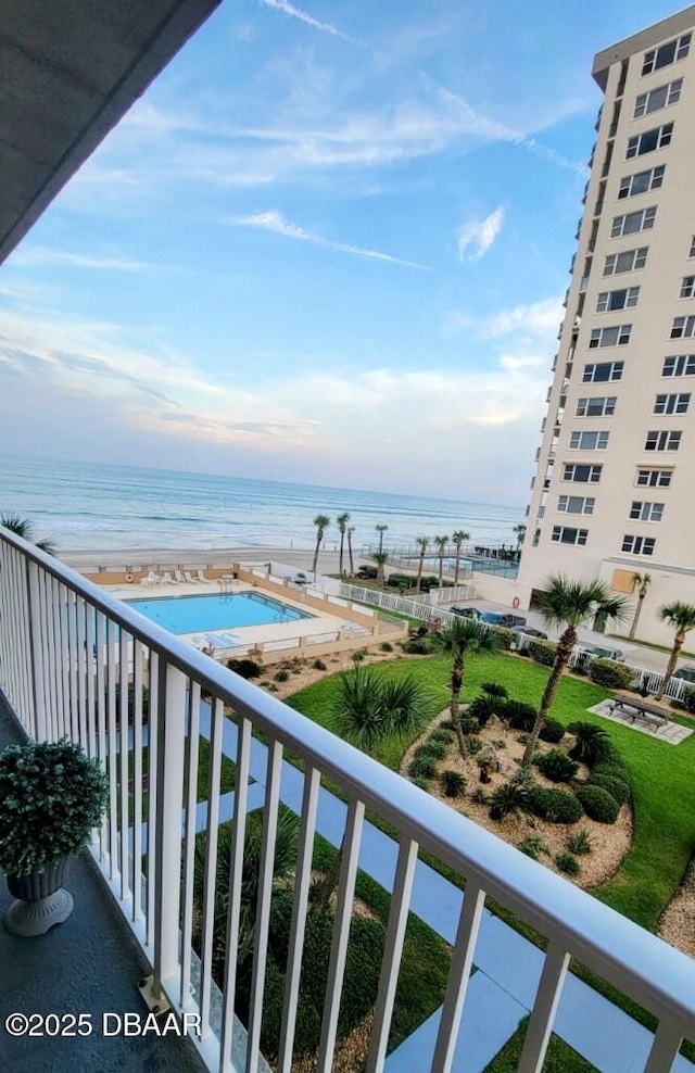 balcony featuring a view of the beach and a water view