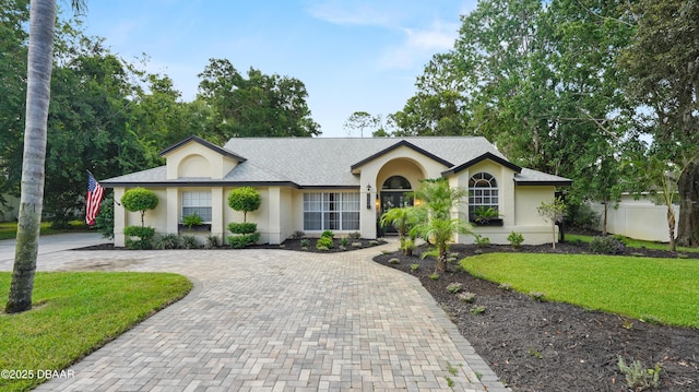 156 Holly Hill Ct, New Smyrna Beach, FL 32168 - ranch-style house with curved driveway, stucco siding, and a shingled roof