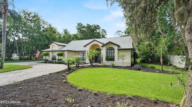 156 Holly Hill Ct, New Smyrna Beach, FL 32168 - ranch-style home featuring stucco siding, decorative driveway, and roof with shingles