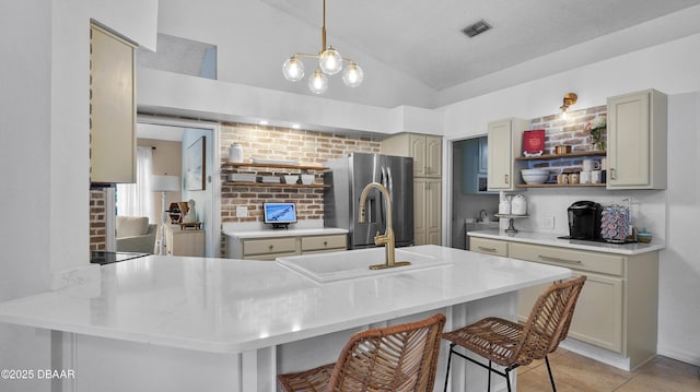 156 Holly Hill Ct, New Smyrna Beach, FL 32168 - kitchen featuring stainless steel fridge, open shelves, vaulted ceiling, light tile patterned floors, and a breakfast bar area