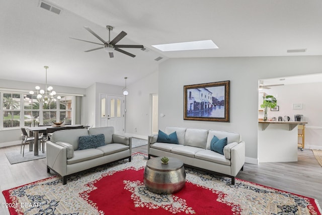 113 Bridgehaven Dr, Palm Coast, FL 32137 - living area with wood finished floors, ceiling fan, vaulted ceiling, a chandelier, and a skylight