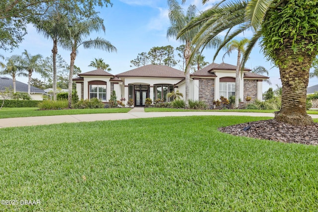 1305 Dovercourt Ln, Ormond Beach, FL 32174 - mediterranean / spanish home with french doors, stucco siding, a front lawn, and stone siding