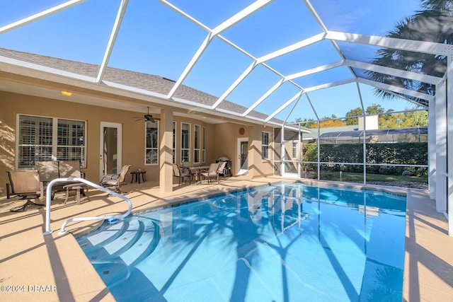 view of swimming pool featuring a patio, ceiling fan, and a lanai