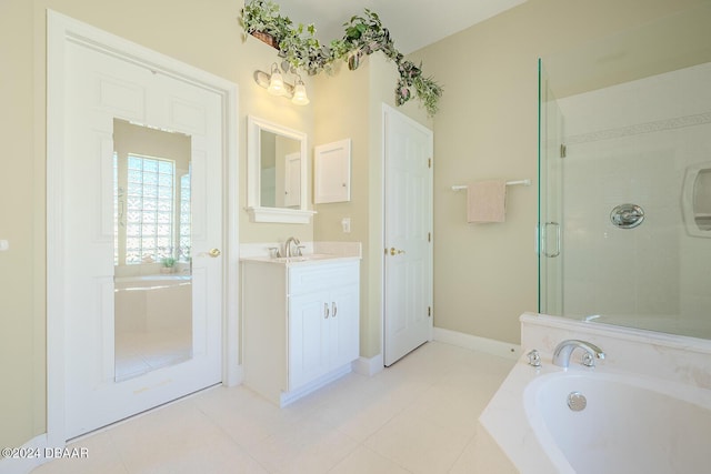 bathroom featuring plus walk in shower, vanity, and tile patterned floors