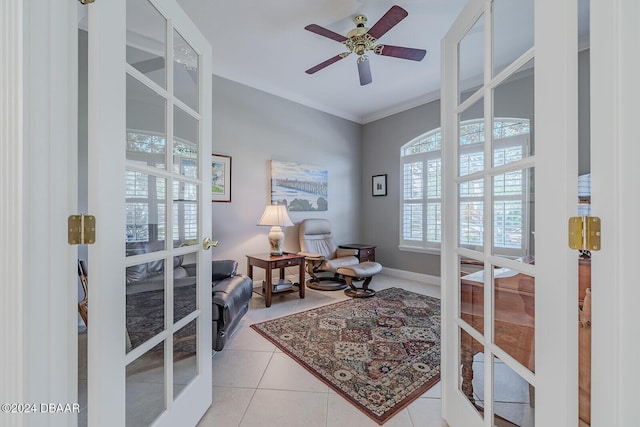 sitting room featuring ceiling fan, french doors, light tile patterned flooring, and crown molding