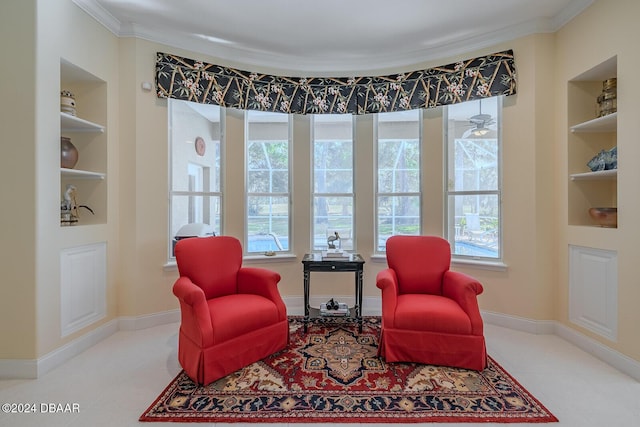 sitting room with built in features and ornamental molding