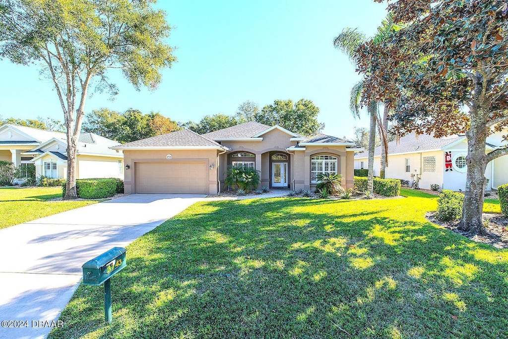 single story home featuring a front lawn and a garage