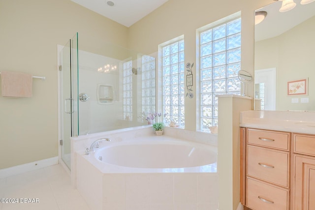 bathroom featuring shower with separate bathtub, vanity, and tile patterned floors